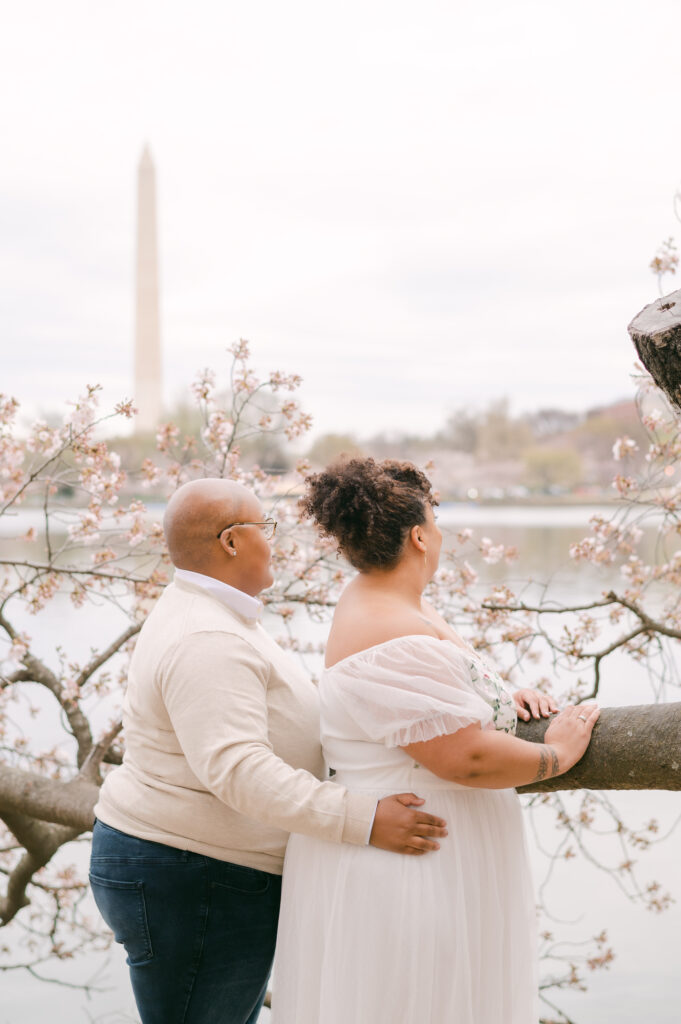 LGBTQ+ couple kissing under the cherry blossoms in Washington, DC for a wedding anniversary session by fine art wedding photographer Kathleen Marie Ward Photography